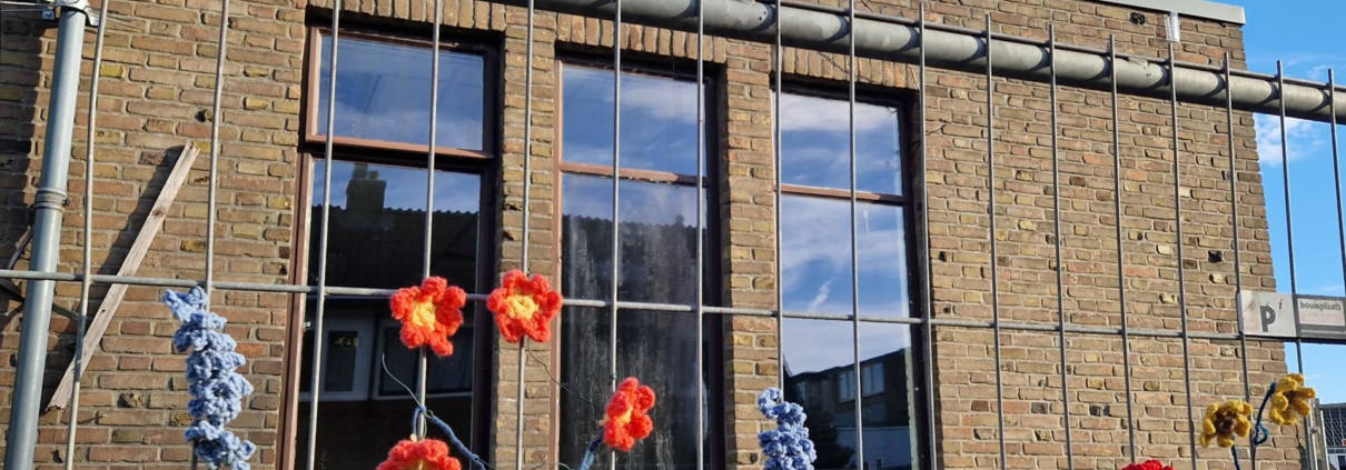 Bouwhek opgevrolijkt door bloemen van wildbreien.