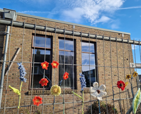 Bouwhek opgevrolijkt door bloemen van wildbreien.